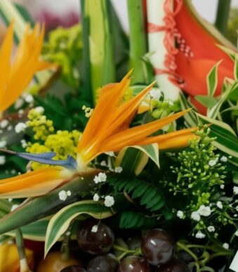 Primer plano extremo de un arreglo floral con frutas Platonia, destacando la textura hiperrealista de las flores, sutiles got