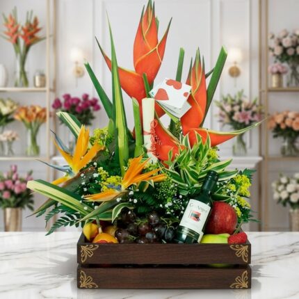 Arreglo Floral con Frutas Platonia en una caja de madera, con flores exóticas como aves del paraíso y heliconias, uvas, manza