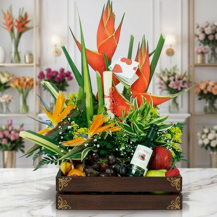 Arreglo Floral con Frutas Platonia en una caja de madera, con flores exóticas como aves del paraíso y heliconias, uvas, manza