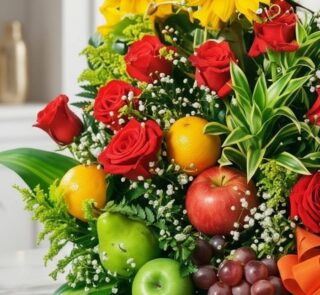 Primer plano extremo de Arreglo Floral con Frutas Trópico, mostrando rosas rojas, girasoles, naranjas, manzanas, peras y uvas