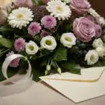 Arreglo floral fúnebre Sereno "Jardín de Ines" con rosas malva, gerberas blancas, crisantemos morados, lisianthus blancos y f