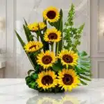 Arreglo floral exótico y grande con girasoles Bengala de pétalos amarillos intensos y centros oscuros, hojas verdes exuberant