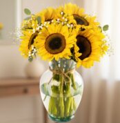 Arreglo floral de girasoles vibrantes en un jarrón de cristal transparente con lazo de yute, sobre un fondo elegante y suavem