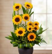 Arreglo floral GIULIANA con girasoles radiantes en un jarrón oscuro, ideal para ecommerce de floristería, con fondo elegante