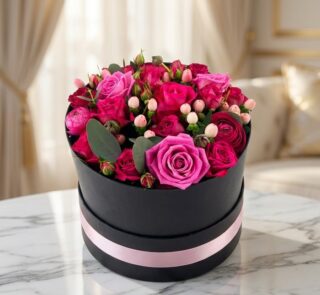 Arreglo floral LILIAN en caja negra con cinta rosa, lleno de rosas lila y rojas, ideal para regalar.