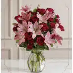 Arreglo floral Nabila con 30 rosas rojas y lirios rosados en un jarrón de cristal, ideal para ecommerce.