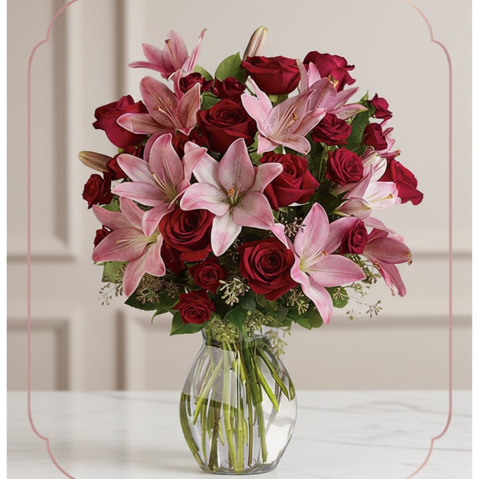 Arreglo Floral Nabila: Majestuoso Ramo de 30 Rosas y Lirios Rosados Arreglo floral Nabila con 30 rosas rojas y lirios rosados en un jarrón de cristal, ideal para ecommerce.