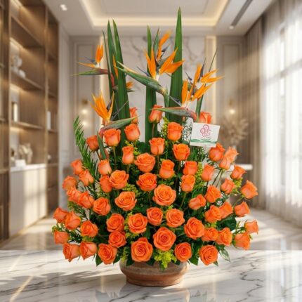 Impresionante arreglo floral exótico con rosas naranjas vibrantes y aves del paraíso, sobre una superficie de mármol en un en