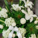 Arreglo fúnebre Adiós Para Siempre con lirios blancos, rosas blancas, hortensias y follaje verde, con rocío sutil y cinta sat