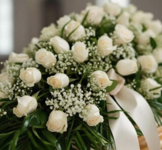 Fotografía macro premium del Arreglo Fúnebre Cubre Caja Cielo, con rosas blancas, follaje verde y rocío sutil. Detalle de cin