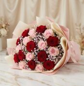 Bouquet ELETRA con 20 rosas rojas y rosadas, envuelto en papel coreano, sobre una superficie de mármol, ideal para regalar am