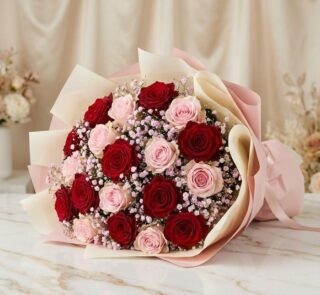 Bouquet ELETRA con 20 rosas rojas y rosadas, envuelto en papel coreano, sobre una superficie de mármol, ideal para regalar am