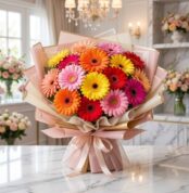 Bouquet Floral Adela, un ramo grande y vibrante de gerberas en tonos rojos, naranjas, amarillos y rosas, con empaque coreano