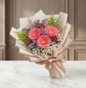Bouquet Floral LIA con gerberas amarillas vibrantes, envuelto en papel coreano elegante, sobre una superficie de mármol pulid