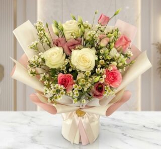 Bouquet Floral SUSANA con rosas blancas y rosadas, astromelias y follaje verde, envuelto en papel coreano rosa y crema, sobre