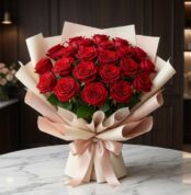 Bouquet MATILDE con 18 rosas rojas vibrantes, empaque coreano elegante en tonos crema y rosa, lazo de satén, sobre mesa de má