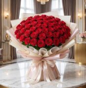 Imponente Bouquet PAOLA con 72 rosas rojas frescas y abiertas, envuelto en elegante empaque coreano, sobre mesa de mármol en