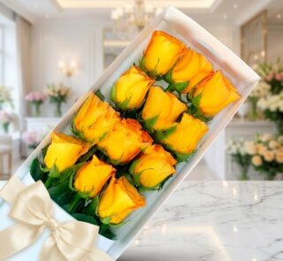 Caja de 12 rosas amarillas frescas y abiertas con un moño elegante, sobre una superficie de mármol en un entorno de florister