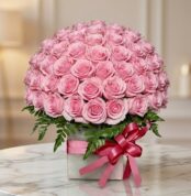 Caja floral Nadia con 72 rosas rosadas frescas y abiertas, dispuestas elegantemente en un arreglo grande y exuberante, con fo