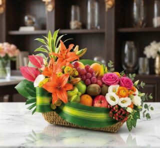 Cesta frutal THALIA con lirios naranjas, anturios rosas, rosas variadas, eustomas blancas y frutas frescas como uvas, manzana