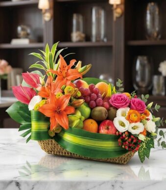 Cesta frutal THALIA con lirios naranjas, anturios rosas, rosas variadas, eustomas blancas y frutas frescas como uvas, manzana