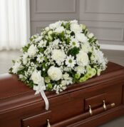 Cubre caja fúnebre Epifania con flores blancas y cinta de condolencia, vista desde un ángulo diferente y composición renovada