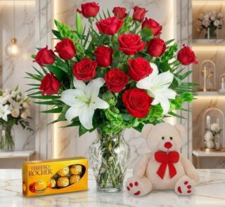 Jarrón Todo Para Ti con un exuberante arreglo floral de rosas rojas y lirios blancos, acompañado de un osito de peluche y cho