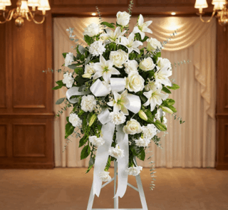 Pedestal conmemorativo Santuario para el Homenaje a PAREDES, con un elegante arreglo floral funerario de rosas blancas, lirio