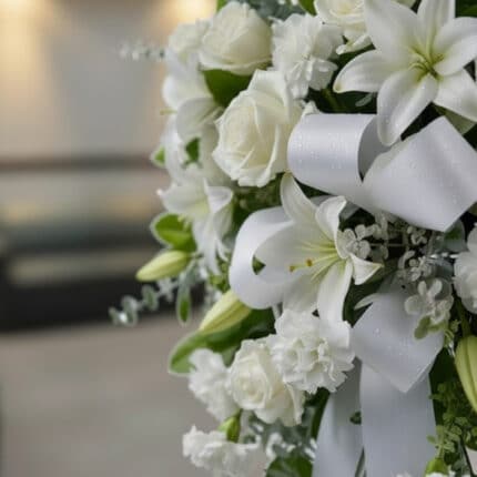 Fotografía macro premium del Pedestal Fúnebre Hasta Pronto, mostrando texturas hiperrealistas de rosas blancas, lirios y foll