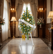 Pedestal fúnebre con rosas blancas y amarillas, ideal para honrar la memoria de un ser querido en una sala de velación elegan