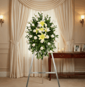 Pedestal fúnebre "Luz de Jacinta" con rosas blancas y lirios amarillos, en una elegante sala de velación con iluminación cáli