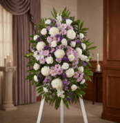 Impresionante pedestal fúnebre de homenaje con flores blancas, lilas y rosadas, ideal para honrar la memoria de Patricio en u
