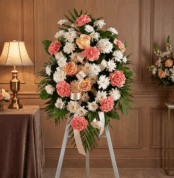 Pedestal fúnebre de homenaje para Timoteo, con arreglo floral de claveles coral, rosas durazno y crisantemos blancos, en sala