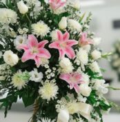 Fotografía macro premium del Pedestal Fúnebre Pasión, mostrando texturas hiperrealistas de pétalos blancos y lirios rosas con