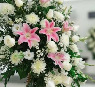 Fotografía macro premium del Pedestal Fúnebre Pasión, mostrando texturas hiperrealistas de pétalos blancos y lirios rosas con