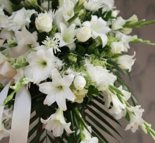 Fotografía macro premium de Pedestal Fúnebre Salvación, con lirios, rosas y gladiolos blancos, follaje verde y rocío sutil. C