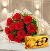 Ramillete de rosas rojas frescas y vibrantes con follaje verde, elegantemente envuelto en papel crema y dorado, junto a una c