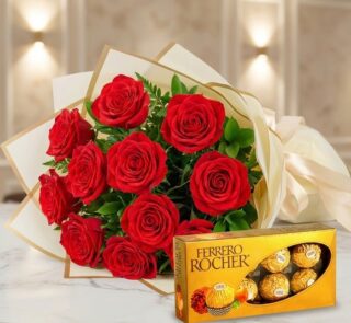 Ramillete de rosas rojas frescas y vibrantes con follaje verde, elegantemente envuelto en papel crema y dorado, junto a una c