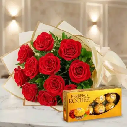 Ramillete de rosas rojas frescas y vibrantes con follaje verde, elegantemente envuelto en papel crema y dorado, junto a una c