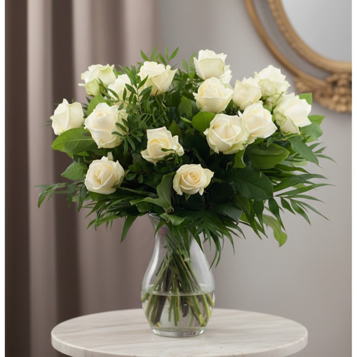 Ramo de 18 Rosas Blancas Serena: Pureza y Elegancia Ramo de 18 rosas blancas frescas en un jarrón de cristal, con follaje verde, sobre una mesa de mármol y fondo elegante.