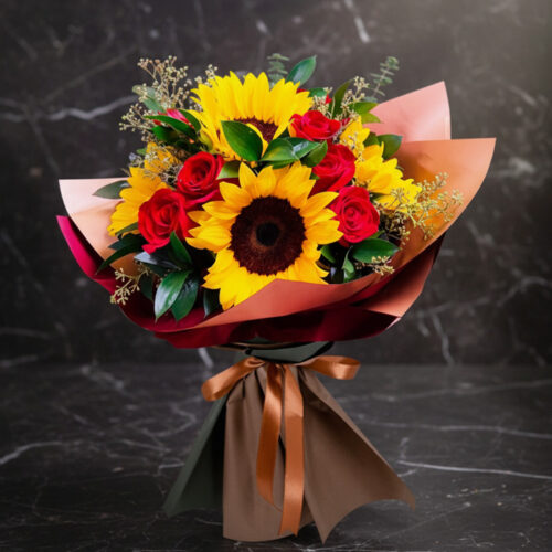 Ramo Aurora de rosas rojas y girasoles vibrantes, envuelto elegantemente en papel de tonos tierra y atado con un lazo de saté