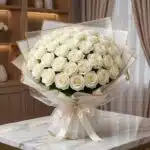 Impresionante ramo JACOBELLA de 60 rosas blancas frescas y abiertas, con empaque coreano elegante y lazo de seda, sobre mesa