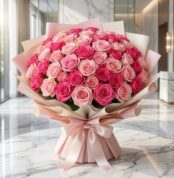 Impresionante ramo de 60 rosas fucsia y rosadas, con empaque coreano elegante, sobre mesa de mármol en floristería premium.